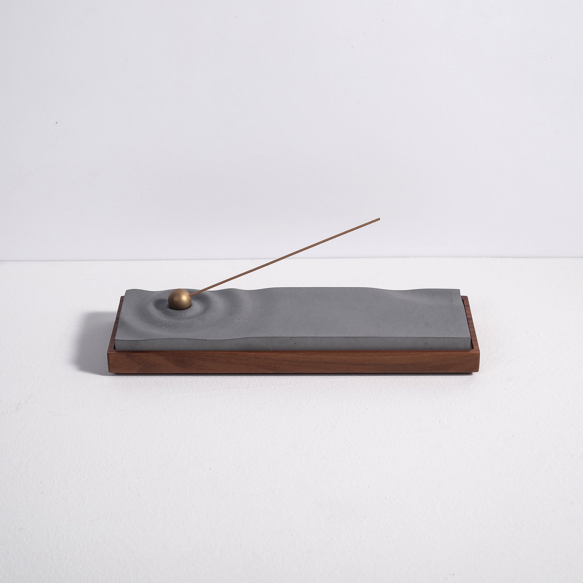 Concrete ripple incense burner with walnut base by Kin Objects