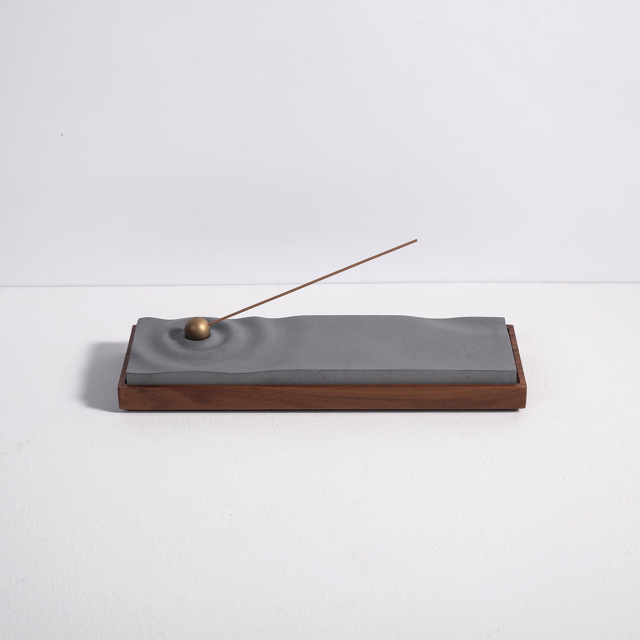 Concrete ripple incense burner with walnut base by Kin Objects